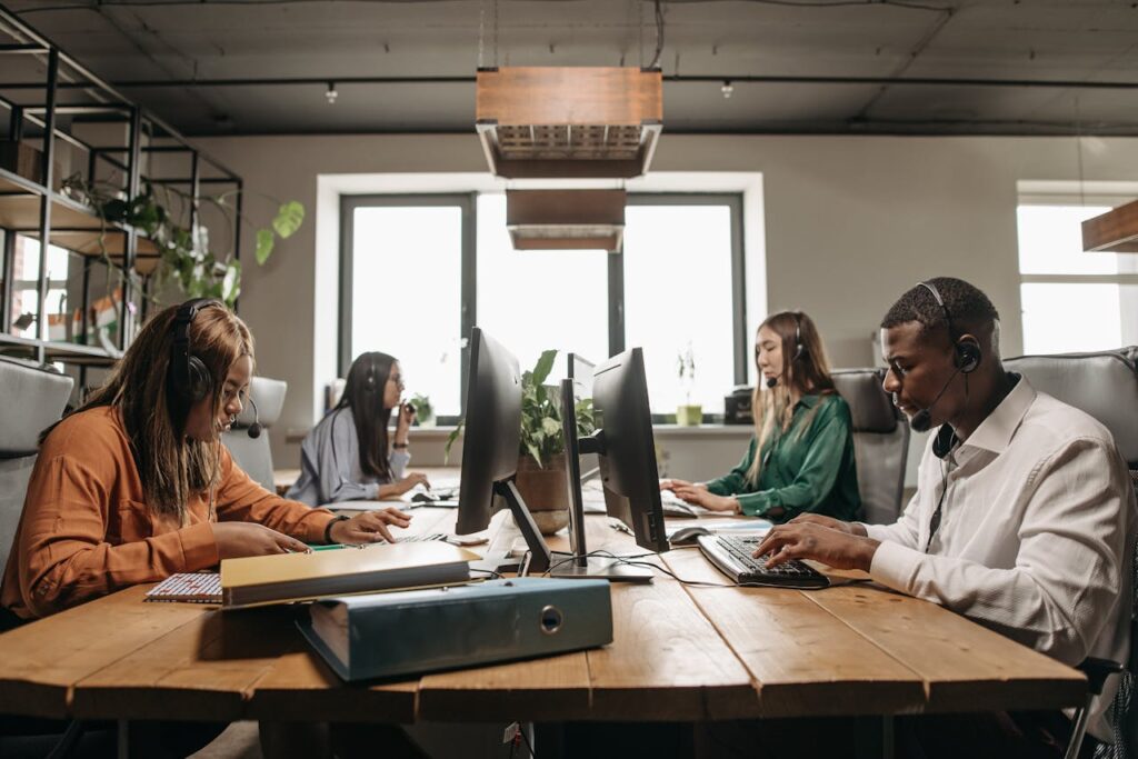 A diverse group of employees collaborating with headsets in a modern office setting.